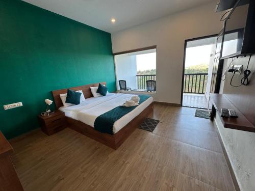 a bedroom with a bed with a green wall at Vagamon Hill Chimes in Vagamon