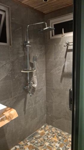 a shower with a shower head in a bathroom at Le Macoua Guest House in Nouvelle Découverte