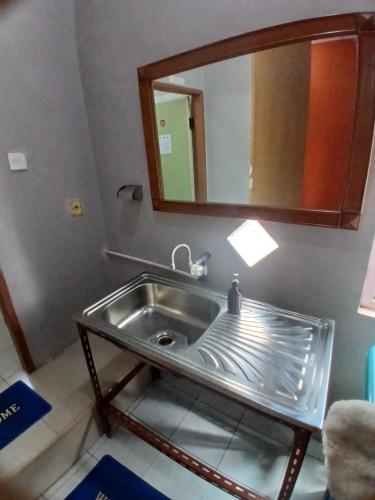 a bathroom with a sink and a mirror at K77 Backpackers - Jungle Tours in Medan