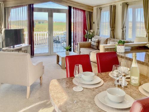 a living room with a table with wine glasses at Ballagan Lodge - Uk43375 in Leanach