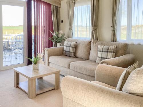 a living room with a couch and a table at Ballagan Lodge - Uk43375 in Leanach