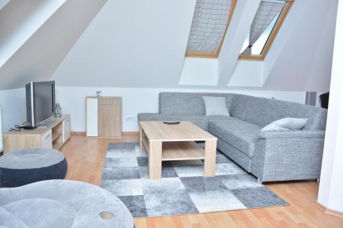 ein Wohnzimmer mit einem Sofa und einem Tisch in der Unterkunft Apartmá Kateřina Velké Losiny in Velké Losiny