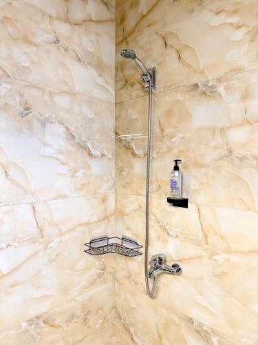 a shower in a bathroom with a stone wall at Avra Yard Suites in Pefkochori