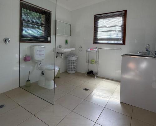 a bathroom with a toilet and a sink at Coffs Coast Mountain Retreat Cabin 1 in Coramba