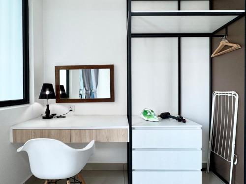 a bedroom with a white desk and a white chair at Alinea Suites in Shah Alam