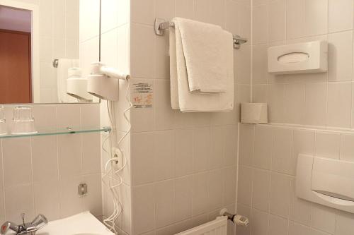 a white bathroom with a shower and a sink at Europahaus Wien in Vienna