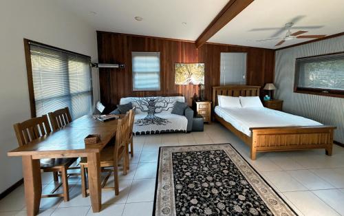 a bedroom with a bed and a table and a couch at Coffs Coast Mountain Retreat Cabin 1 in Coramba