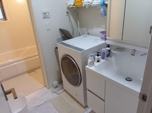 a washing machine in a bathroom with a sink at バイキング樫本 in Hirakata