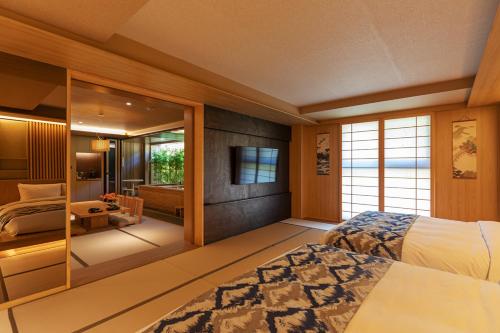 a bedroom with a large bed and a television at Hoshikage Ryokan Hotel in Busan
