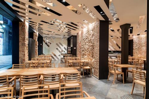 a restaurant with wooden tables and chairs at Barcelona House in Barcelona