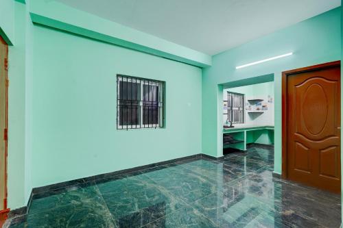 a room with blue walls and a wooden door at Hotel O White Inn in Chennai