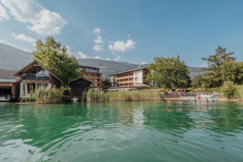 a large body of water with houses and buildings at Hotel SeeRose in Bodensdorf