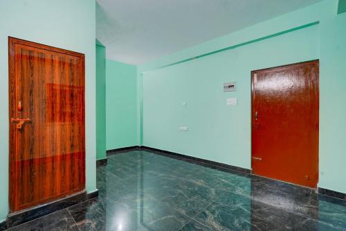 a room with a red door and a tile floor at Hotel O White Inn in Chennai