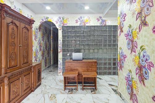 a room with a desk and a wall with flowers at Queen Residence Ancol RedPartner in Jakarta