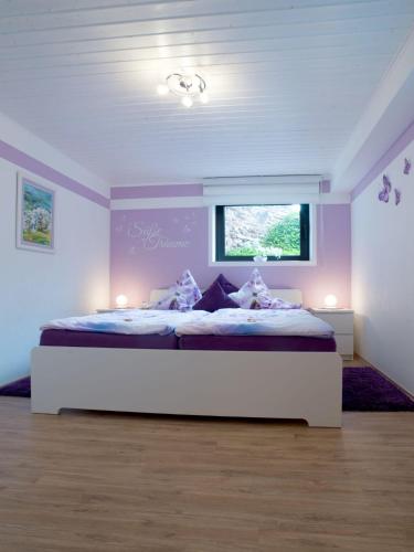 a bedroom with a large bed with purple walls at Ferienwohnung Alexandra in Mettlach