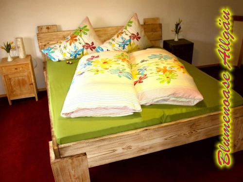Una cama con dos almohadas encima. en Blumenoase Allgäu, en Schwanden