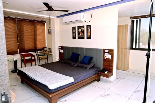 a bedroom with a bed with blue pillows and a table at hotel cloud 20 in Jambusar