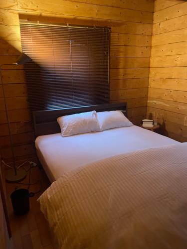 a bedroom with a bed in a wooden room at A Sleeping Forest in Ito