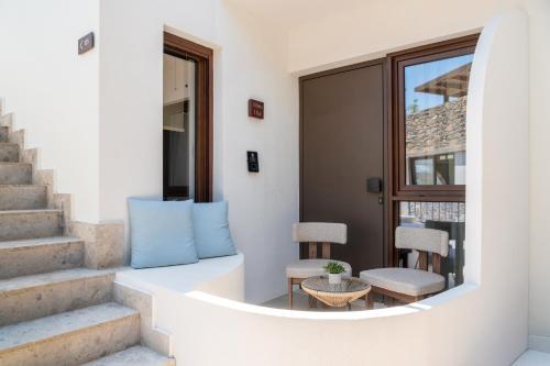 a balcony with a blue pillow and two chairs at Elounda Stories Boutique Hotel in Elounda