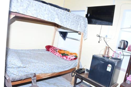 a bunk bed in a room with a tv at Sarla Resort in Sawāi Mādhopur