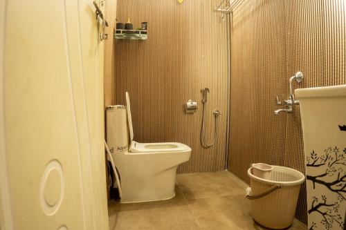 a small bathroom with a toilet and a shower at The Leafyard Container Home in Venkatāpur