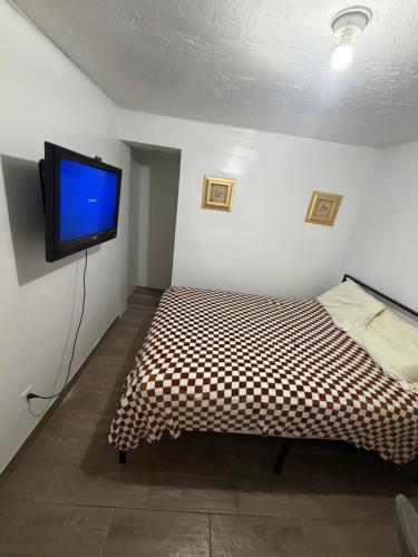a bedroom with a bed and a flat screen tv at Downtown Taylor Room 5 in Phoenix