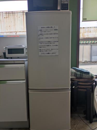 a white refrigerator freezer sitting in a kitchen at Hostel x Hair ie in Hadano