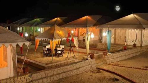a group of tents with tables and chairs under them at Sarla Resort in Sawāi Mādhopur