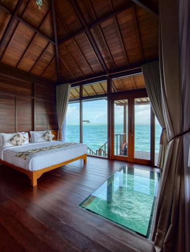 a bedroom with a bed and a glass table at Leebong Island Resort in Leebong