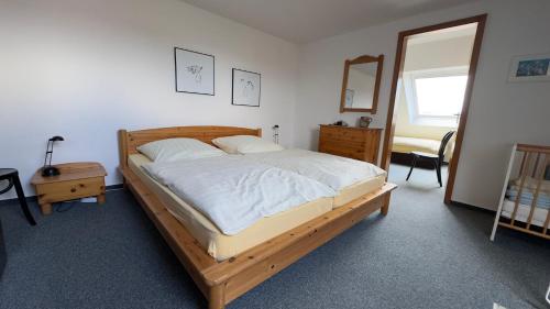 a bedroom with a large bed with a wooden frame at Ferienwohnung Uns Huus in Langeoog