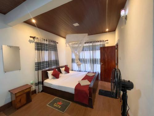 a bedroom with a bed and a large window at The Grand Residence in Ella