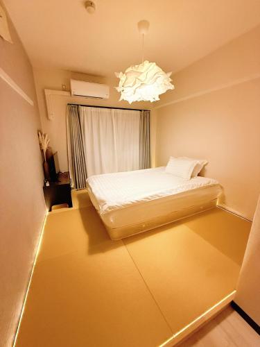 a bedroom with a bed and a chandelier at 和605 名駅徒歩圏 地下鉄徒歩3分 最大4名 洗面台 浴室 トイレ別 長期滞在可乾燥機付き in Nagoya