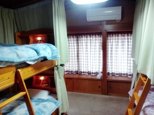 a room with two bunk beds and a window at Guest House Honami-Kaido in Yamanouchi