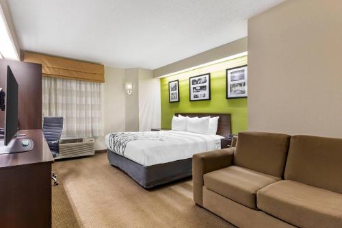 a hotel room with a bed and a couch at Sleep Inn at Greenville Convention Center in Greenville