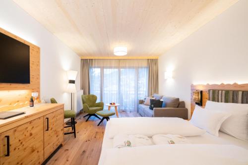 a hotel room with a bed and a living room at Hotel Trattlerhof in Bad Kleinkirchheim