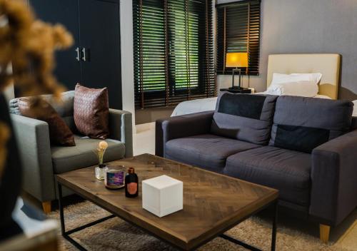 a living room with two couches and a coffee table at Base 22 Hatyai in Ban Rai