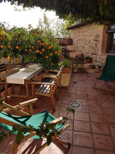 an outdoor patio with tables and chairs and oranges at El Atalanto in Madrigal de la Vera