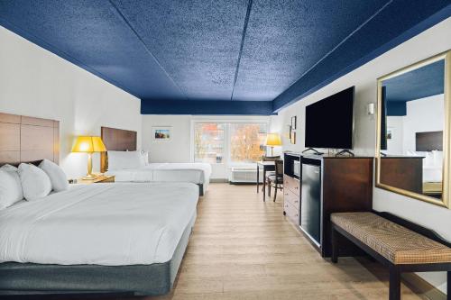 a hotel room with two beds and a flat screen tv at Hotel Downstreet, an Ascend Collection Hotel in North Adams