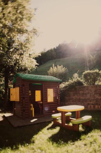 a small wooden cabin with a table and a bench at Hotel Michela in Malè