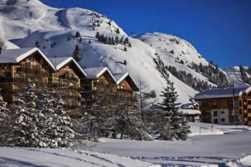 a building in the snow with a snow covered mountain at Hollandia 26 in Riederalp