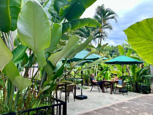 people sitting at tables with umbrellas and plants at Wave-F in Ko Kood