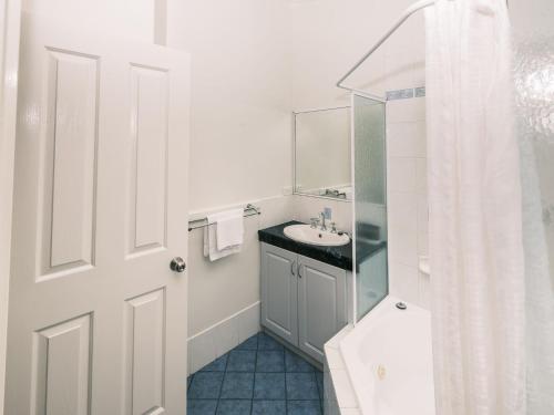 a white bathroom with a sink and a shower at BIG4 Middleton Beach Holiday Park in Albany