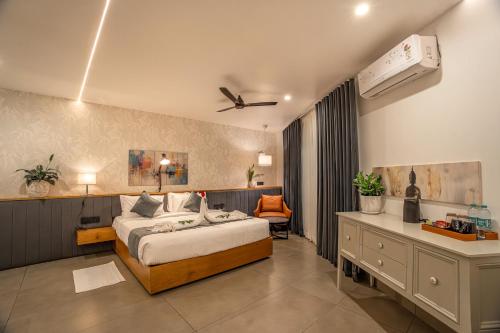 a bedroom with a bed and a dresser and a desk at Aura Inn & Suites in Mysore