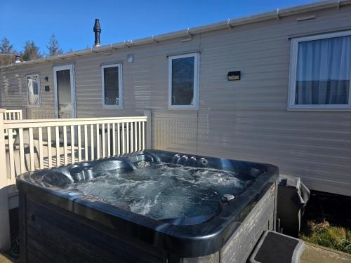 a large hot tub in front of a house at Dixons Den Hot Tub in Swarland