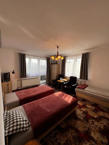 a bedroom with two beds and a living room at Pokoje Gościnne Pod Lasem" in Balice