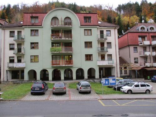 a large building with cars parked in a parking lot at Apartment Mathis & MTB-garage in Jáchymov