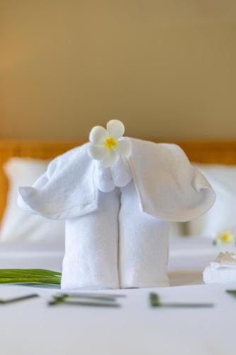 a towel elephant with a flower on a bed at FarmSaijai Kohphangan in Hinkong