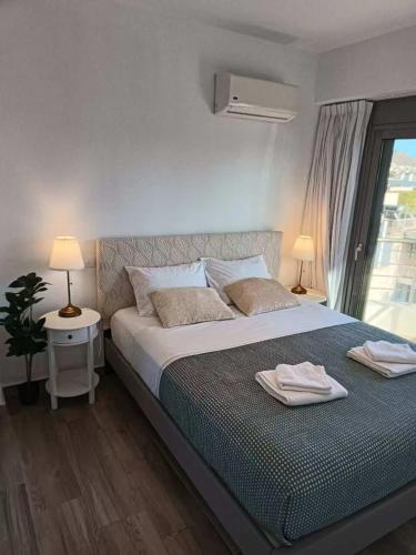 a bedroom with a bed with two towels on it at Voula Pool & Sea View & Beach home B1 in Athens