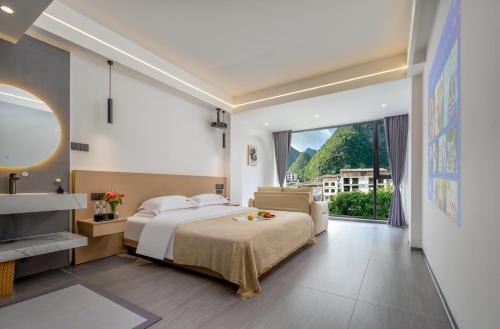 a bedroom with a large bed and a large window at Jiheshan residential accommodation Yulong River Yangshuo in Yangshuo