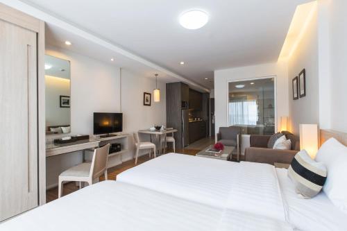 a hotel room with a bed and a living room at Kantary 304 Hotel Prachinburi in Si Maha Phot